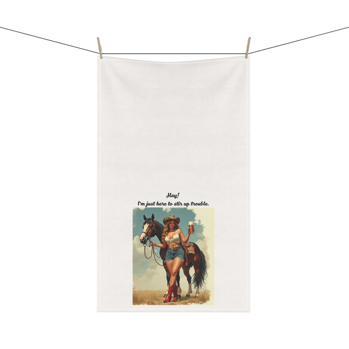 Tea towel with a graphic of a woman on a horse and text, hanging on a line.