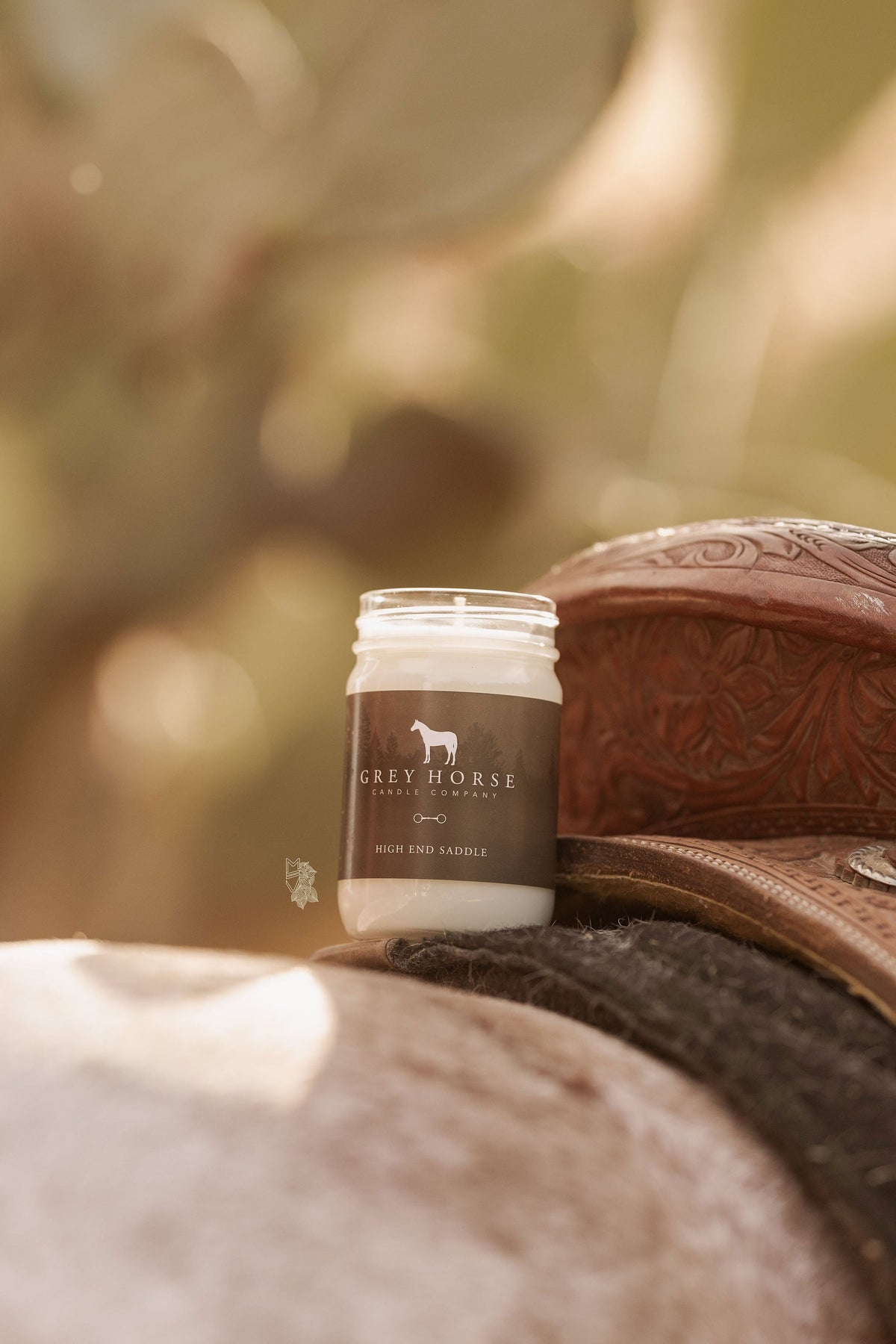 Jar of Grey Horse Cream on a leather bag with a blurred natural background