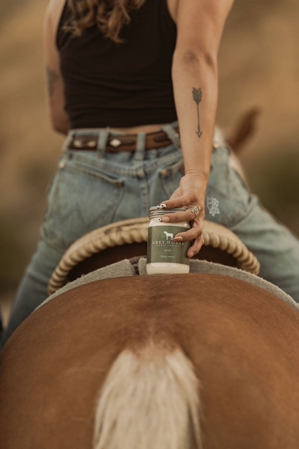 Person on a horse holding a bottle of Lofco products
