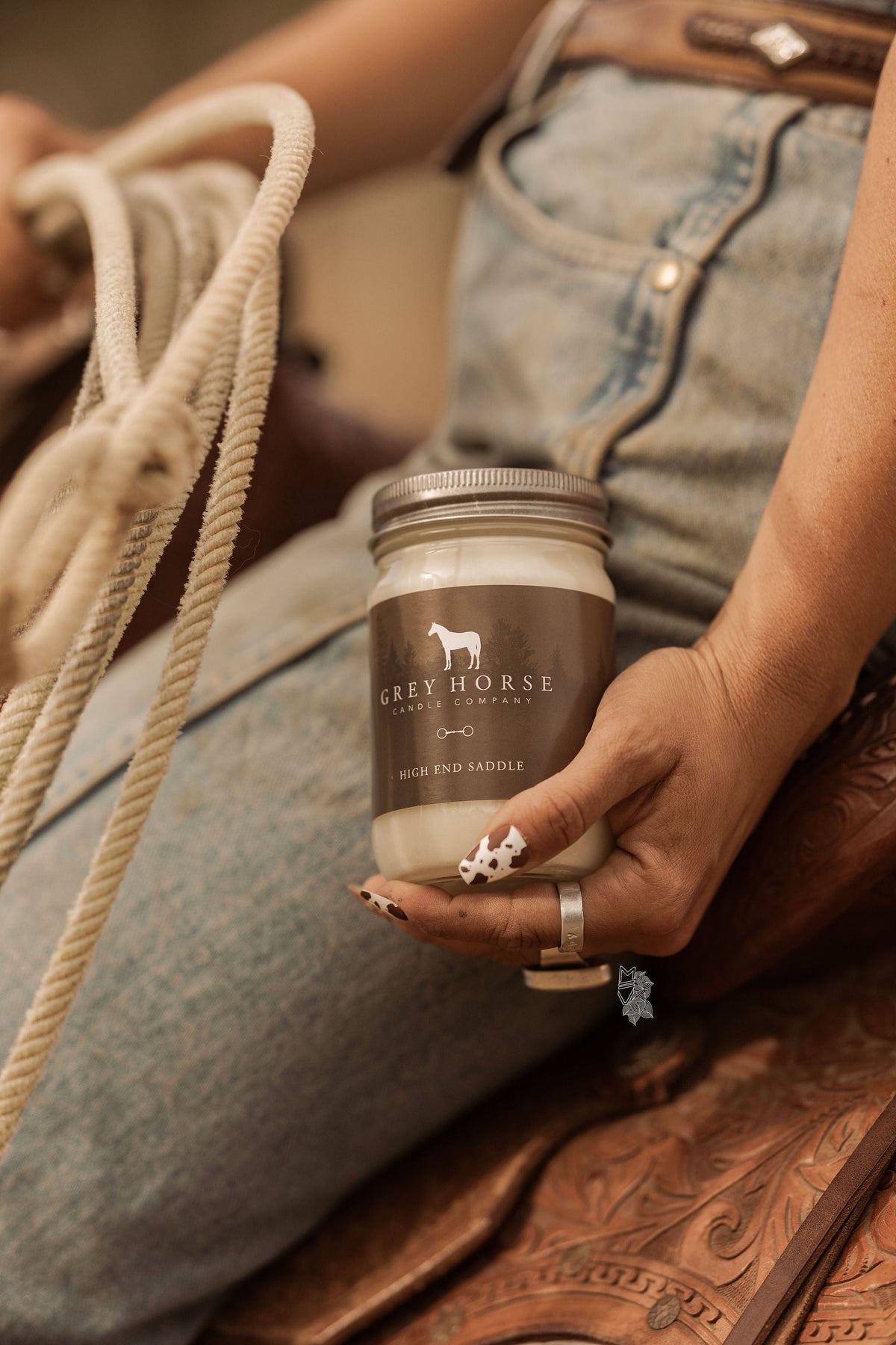 Person holding a jar labeled 'Grey Horse' on a leather surface