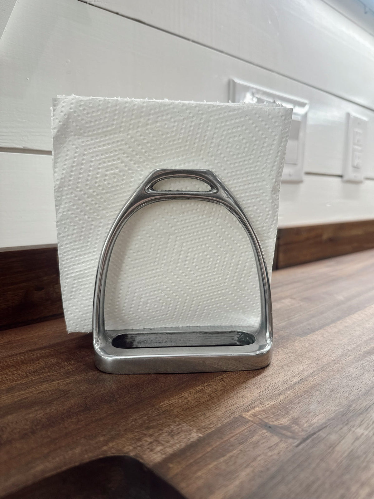 Metal stirrup on a white paper towel with a wooden surface and white wall in the background
