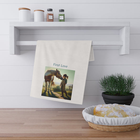 Towel with a printed design of a woman and horse on a wooden surface with a plant and shelf in the background.
