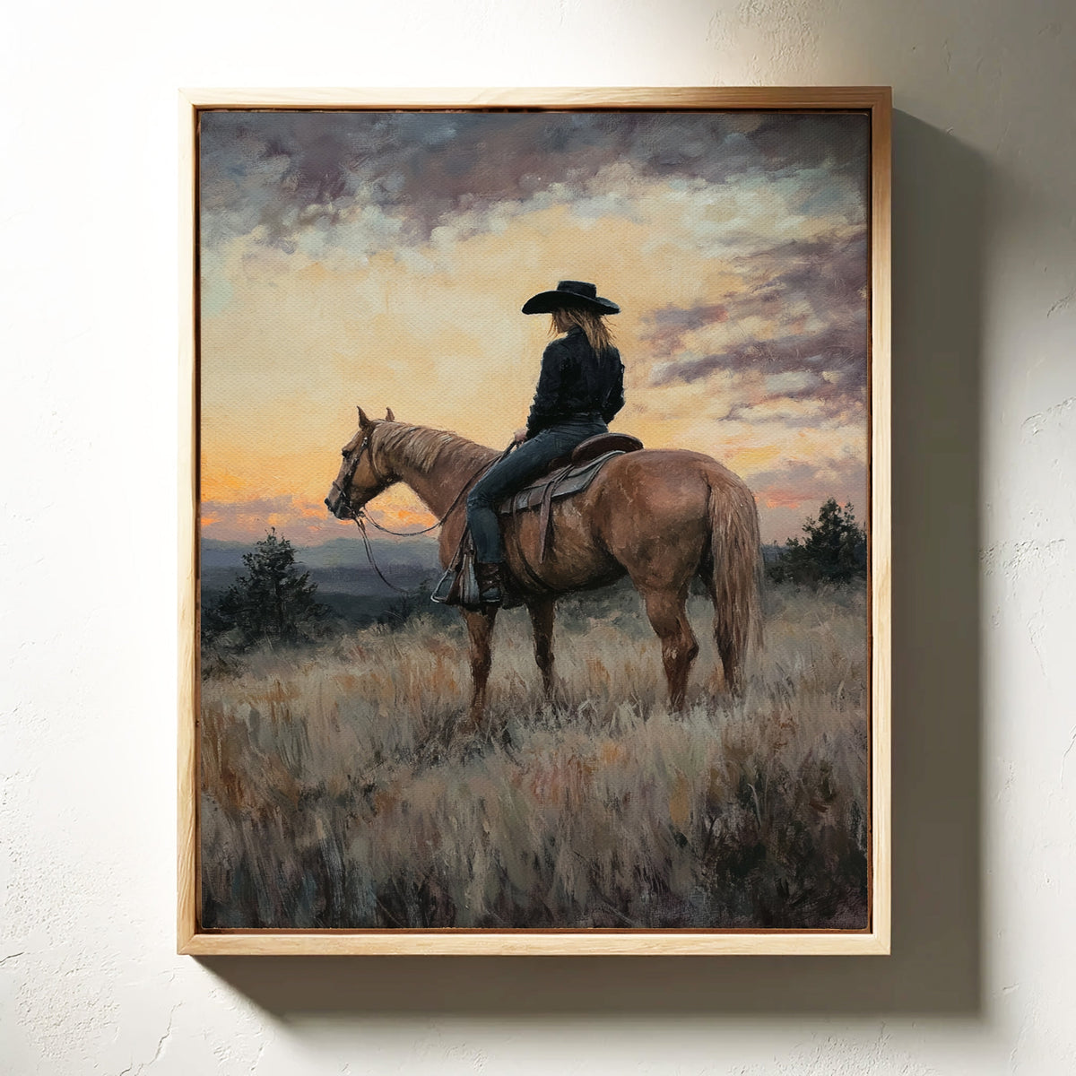 Framed painting of a person on horseback against a sunset sky.