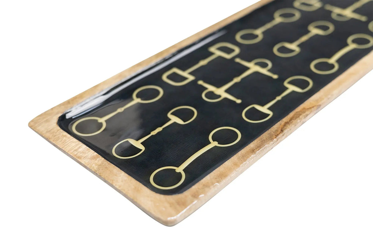 Rectangular black board with gold horse bit designs on a wooden frame