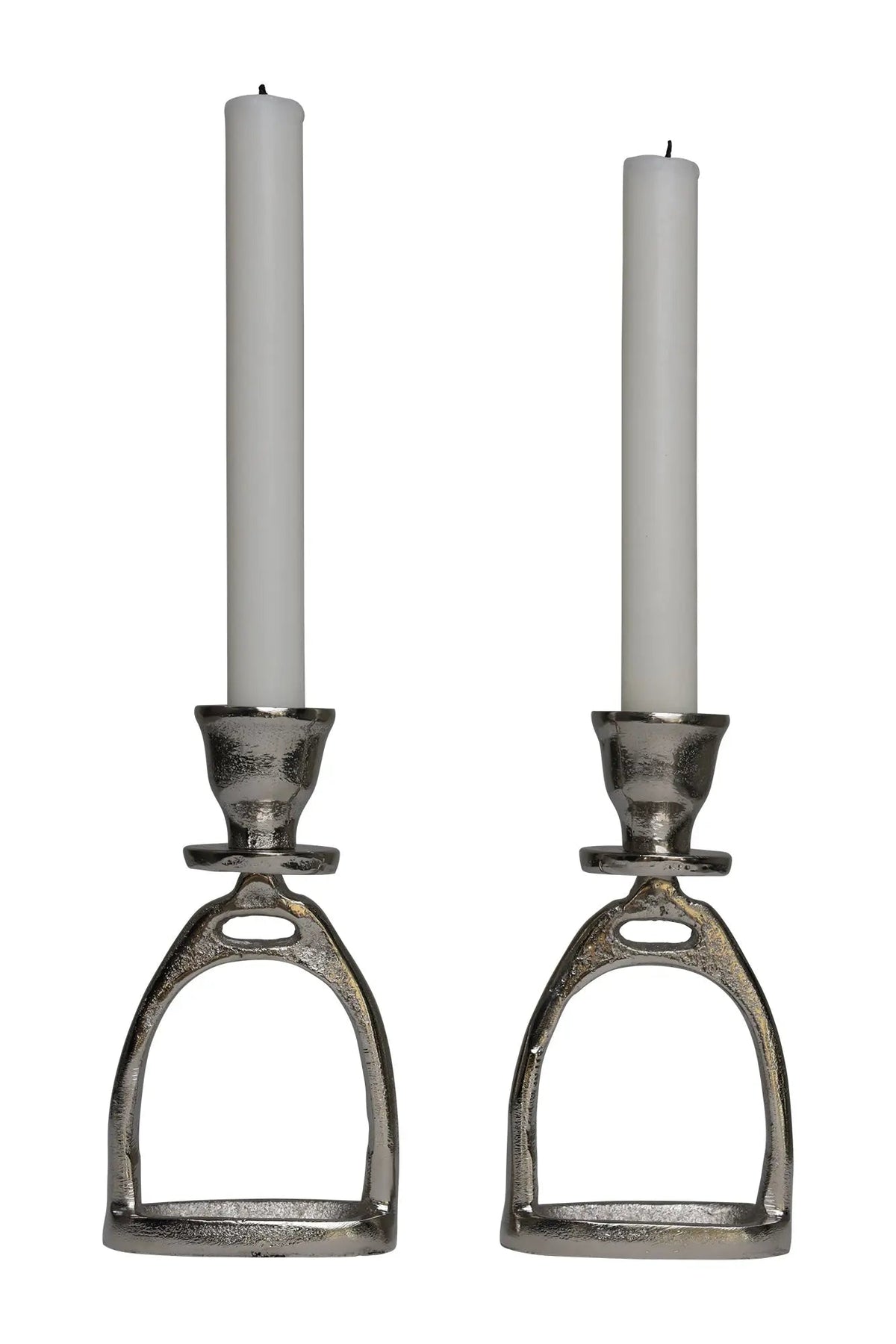 Two candle holders shaped like horse stirrups with white candles on a white background