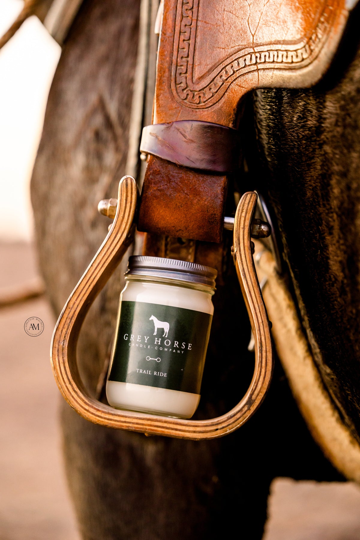 Jar of Grey Horse Leather Conditioner in a leather pocket of a horse saddle.
