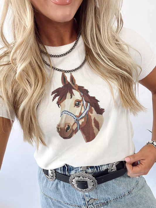 Person wearing a white sweater with a horse graphic design.